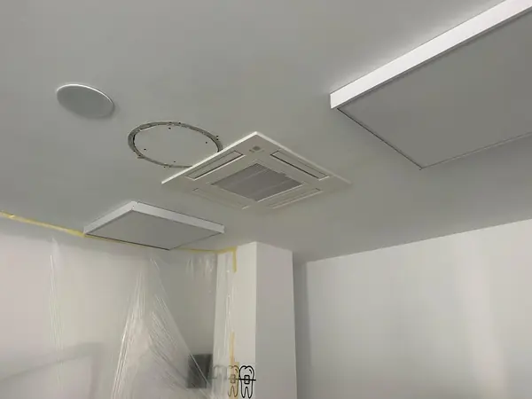 Unidad de cassette recién instalada en el techo de escayola de una sala