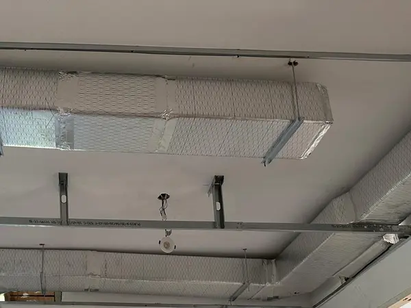 Conductos de climatización colgados de la estructura del falso techo en una vivienda en reforma