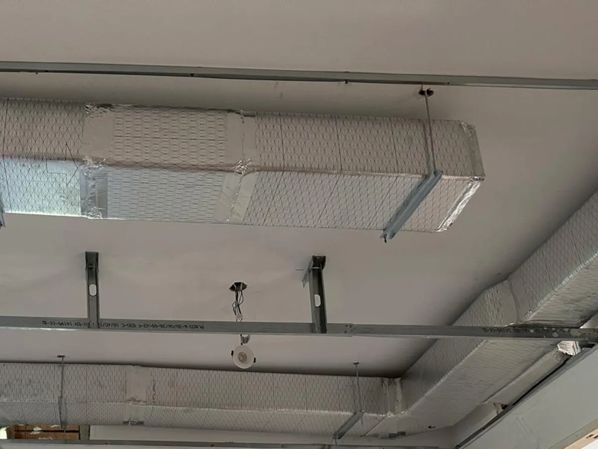 Conductos de climatización colgados de la estructura del falso techo en una vivienda en reforma