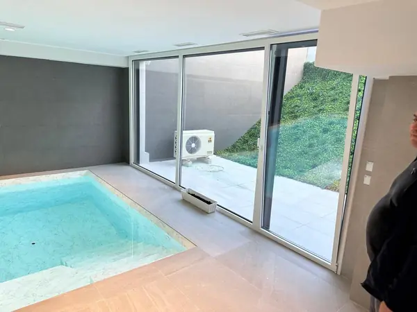 Salón climatizado con unidad de pared y salida directa a la piscina de la vivienda