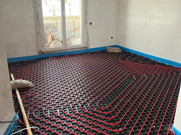 Circuito de suelo radiante ya tendido sobre el panel aislante de una estancia en obra