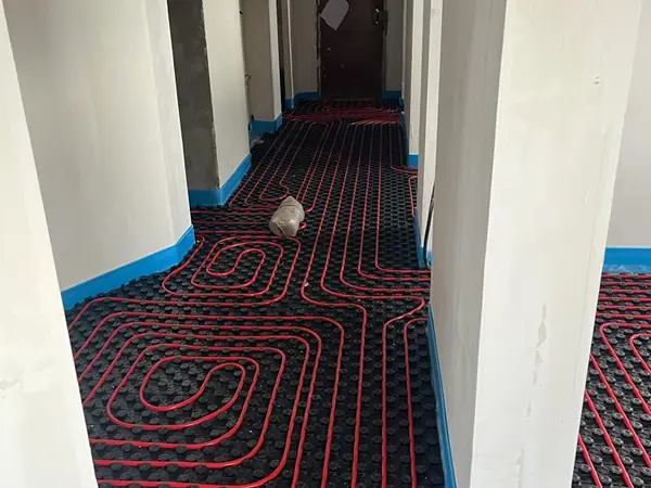 Tubería de suelo radiante recorriendo el pasillo de una vivienda en reforma