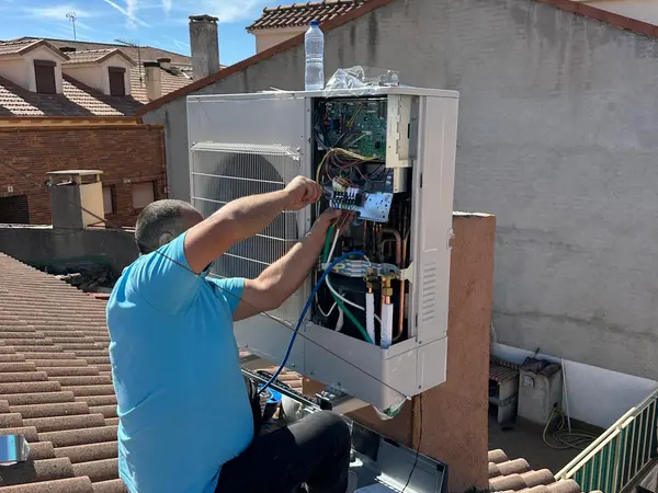Técnico de BioClima21 cableando el cuadro eléctrico de una unidad exterior sobre la cubierta