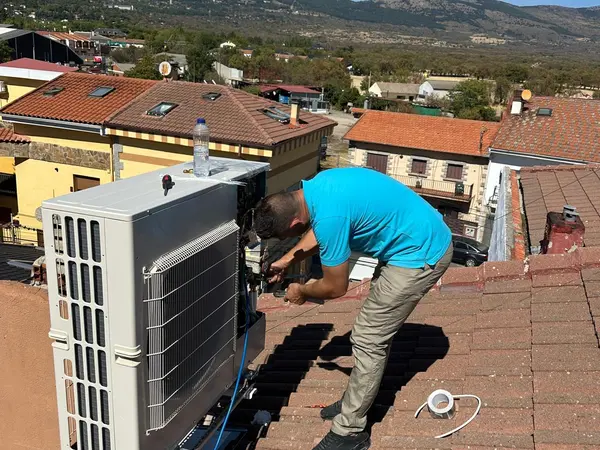Técnico de BioClima21 haciendo las conexiones de una unidad exterior montada junto al tejado
