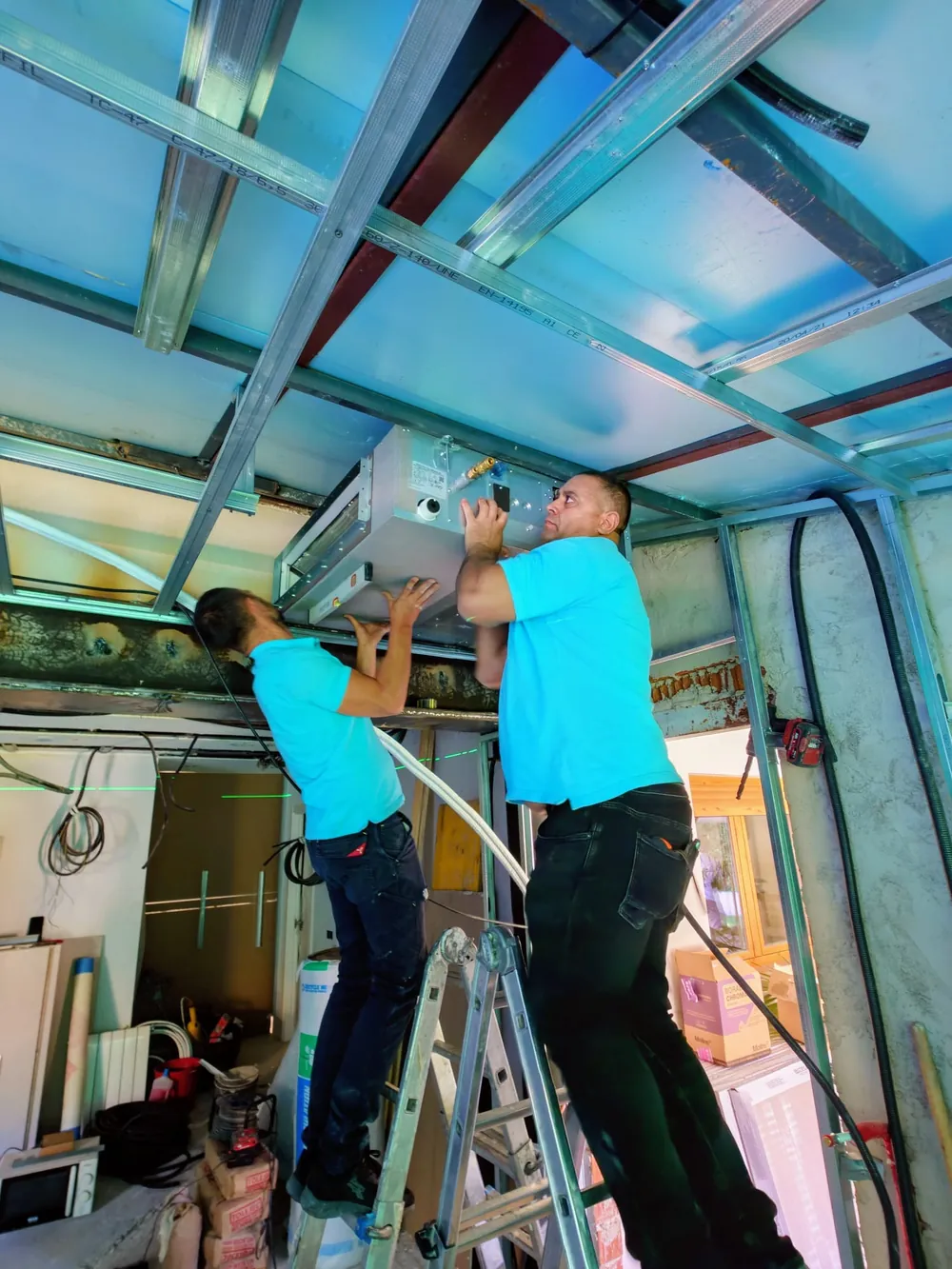 El equipo de BioClima21 colocando la red de conductos en el techo de una vivienda