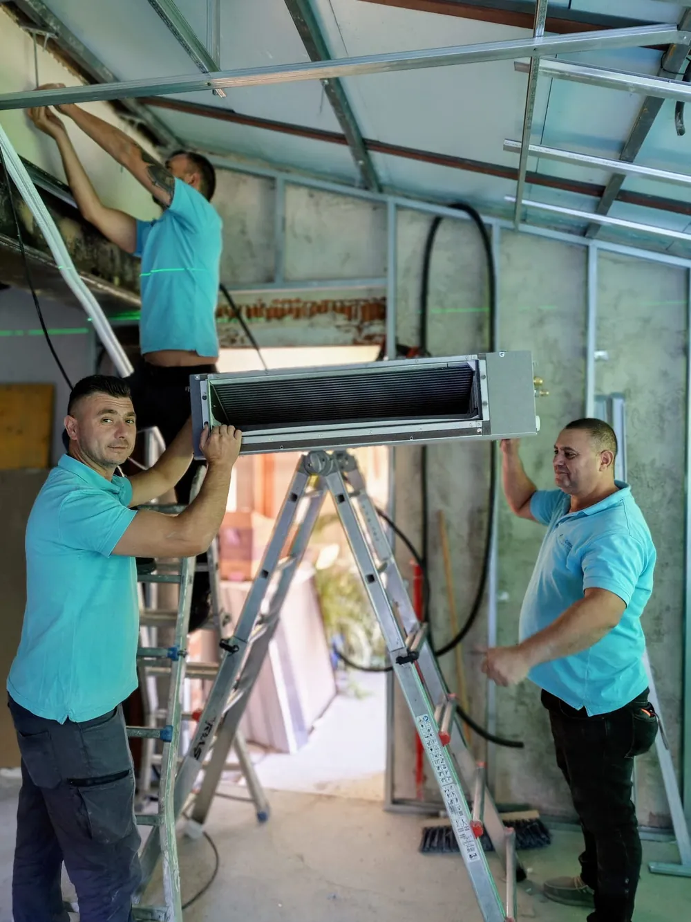 Instalador de BioClima21 subiendo a la escalera la unidad interior por conductos