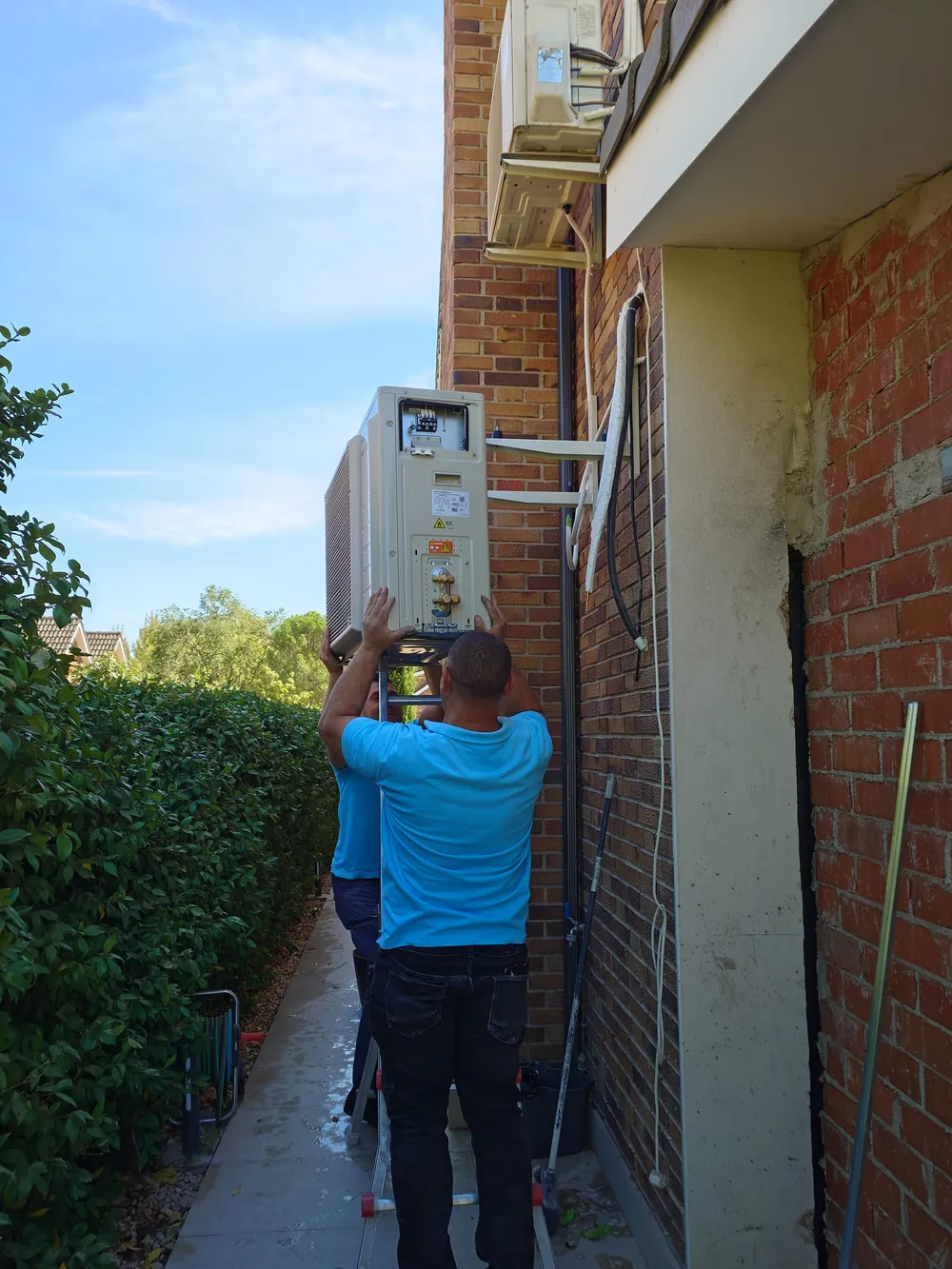 Técnico de BioClima21 ajustando las unidades exteriores instaladas en la fachada de una vivienda
