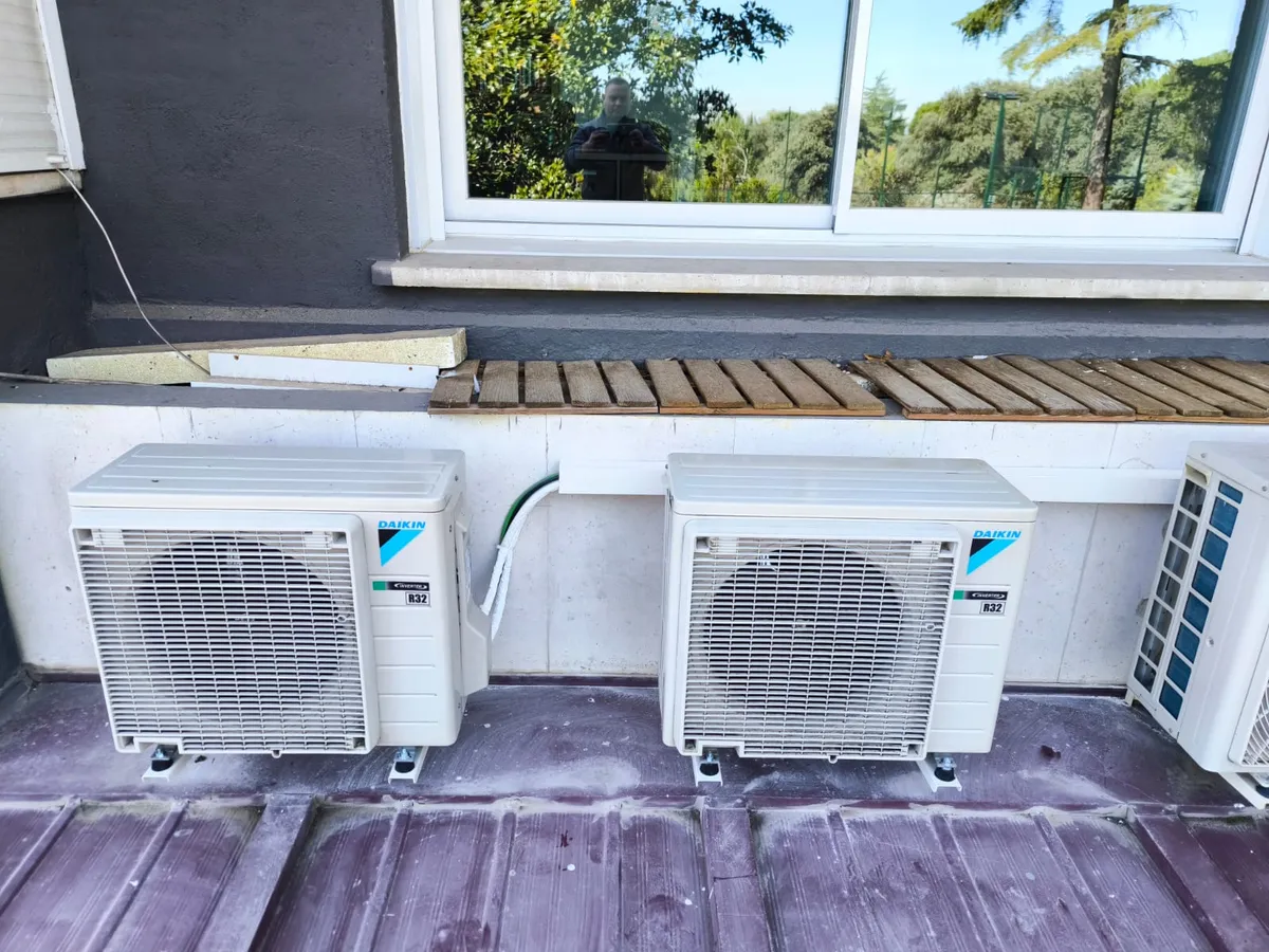 Dos unidades exteriores Daikin R32 revisadas y limpias bajo la ventana de una vivienda