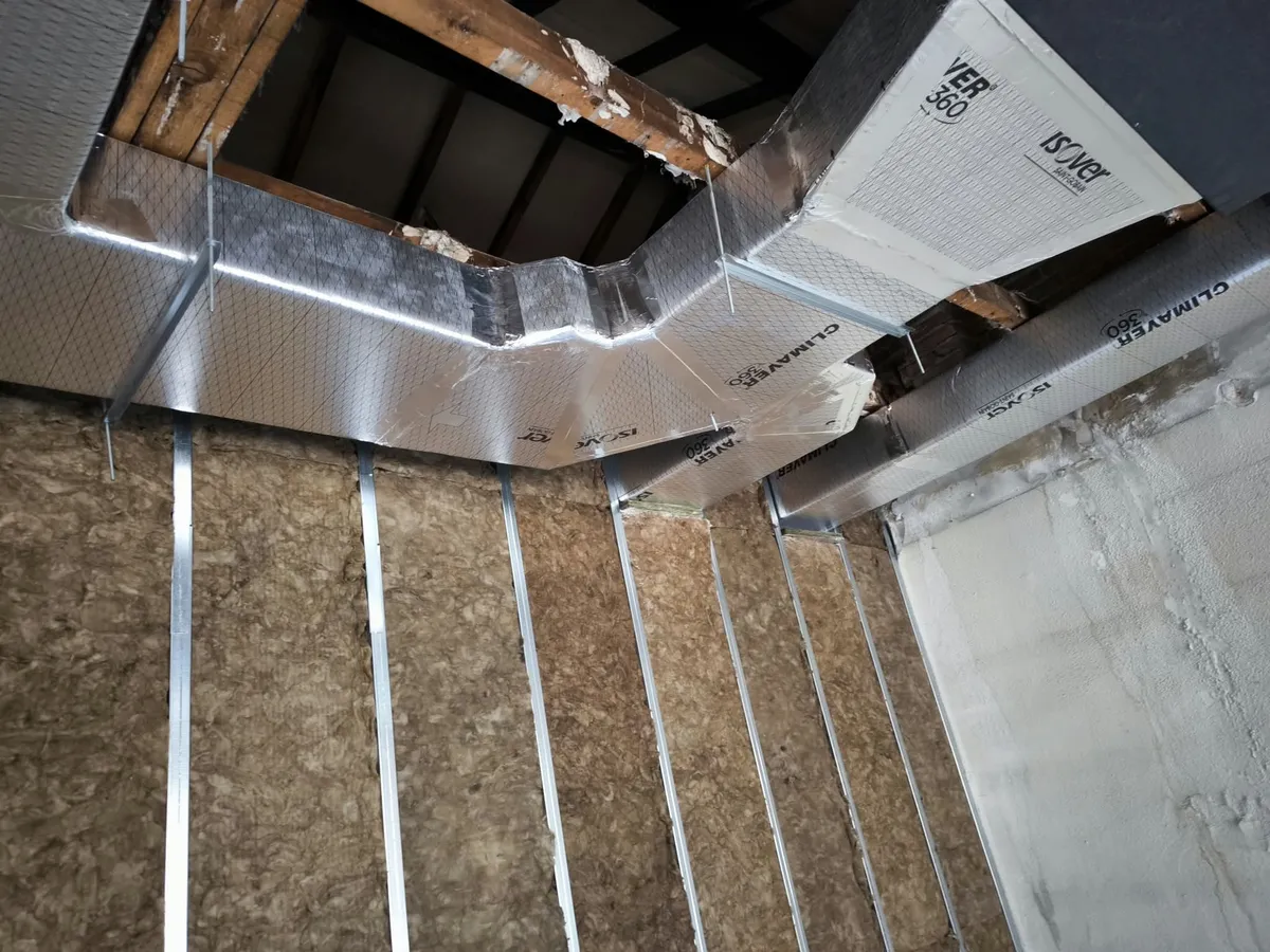 Conductos de climatización aislados y montados bajo la cubierta de una vivienda